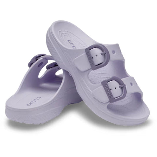 A pair of Crocs Womens Saturday Enamel Buckle Purple Halo Sandal Slides, featuring two adjustable straps with enamel buckles, are shown with one sandal resting on its side behind the other against a white background—delivering signature Crocs Comfort in e