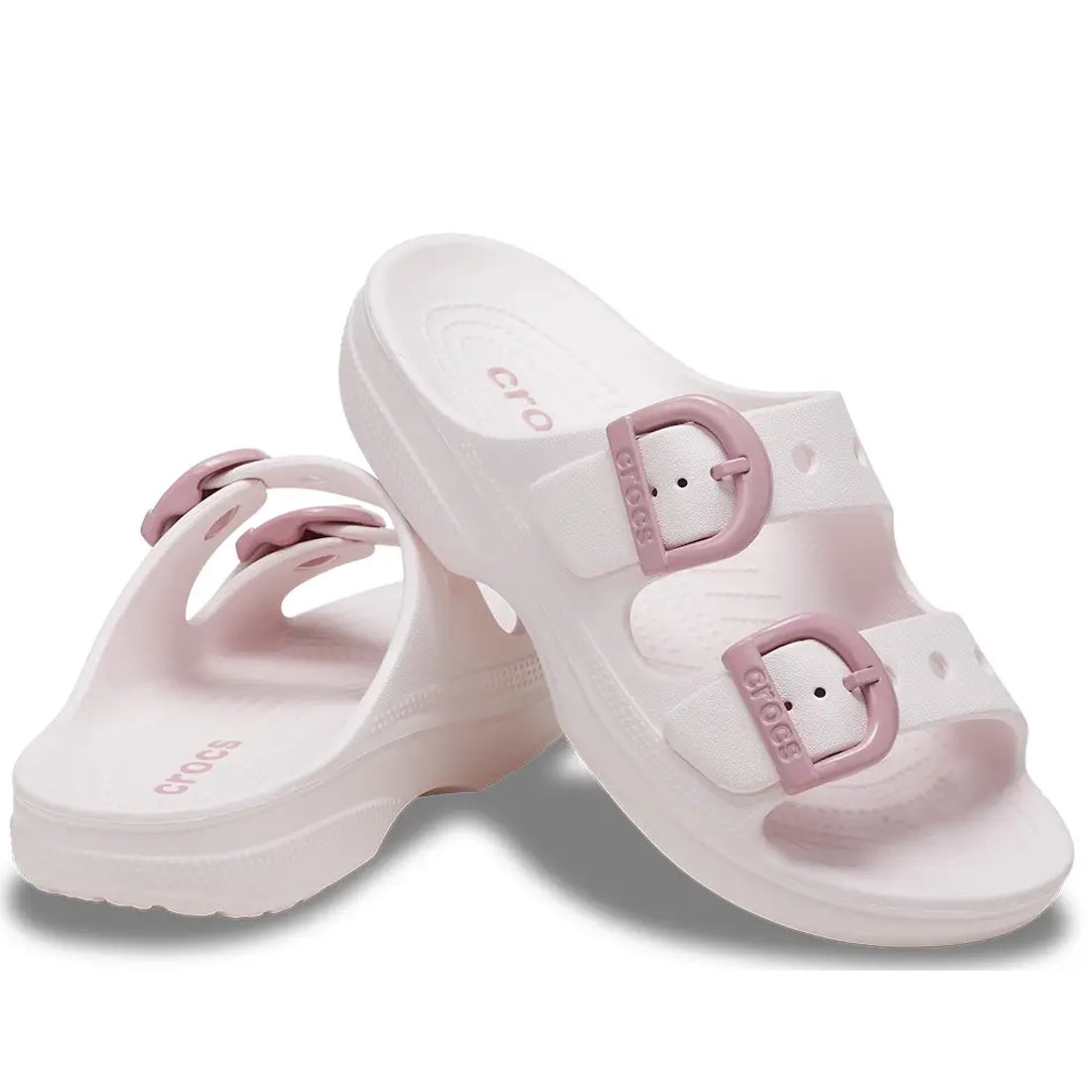 The Crocs Womens Saturday Enamel Buckle Bubble Ice Pink Sandal Slide features a light pink design with two adjustable pink enamel buckles on each strap, offering signature Crocs Comfort. Showcased on a white background, these sandals blend style with all-