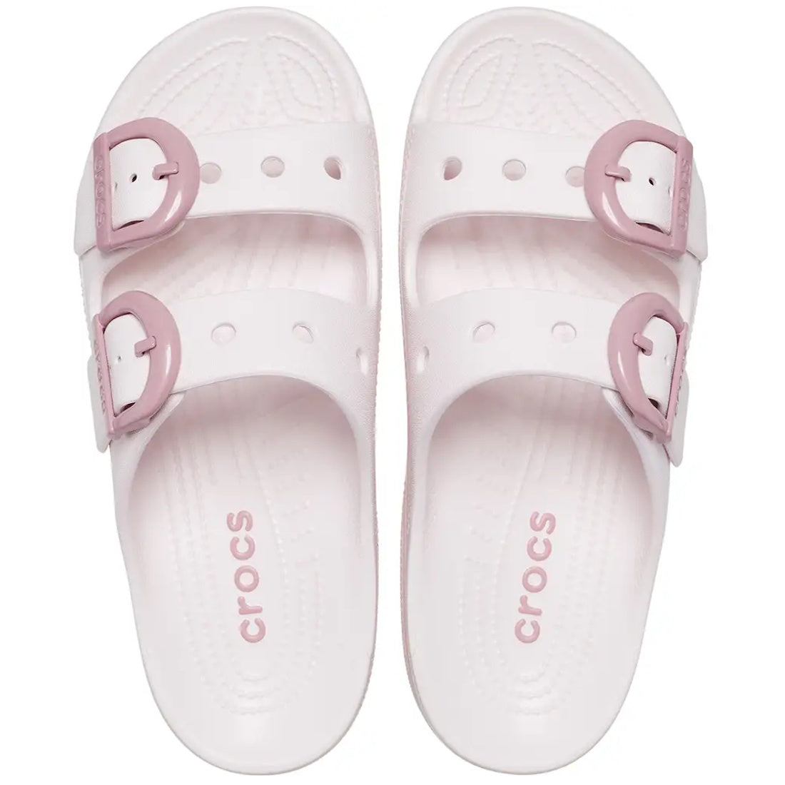 A pair of Crocs Womens Saturday Enamel Buckle Bubble Ice Pink Sandal Slides featuring Crocs Comfort, with two adjustable pink straps on each shoe and the Crocs logo printed in pink on each footbed, viewed from above.
