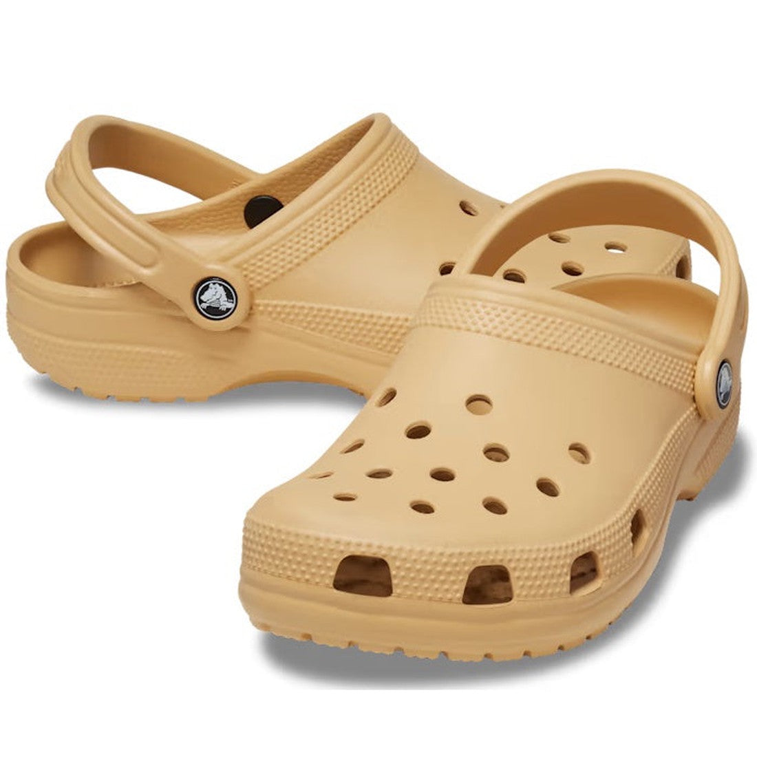The Crocs - Classic Clog Wheat Tan Adults are beige unisex clogs featuring ventilation holes and adjustable heel straps for lightweight comfort, displayed on a white background.