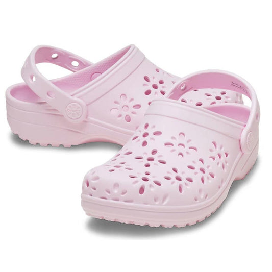 The Crocs Kids - Classic Floral Cut Out Clog K Pink Milk Youths: a comfy pink slip-on with fun floral cutouts, soft sole, and an adjustable back strap.  ksnz