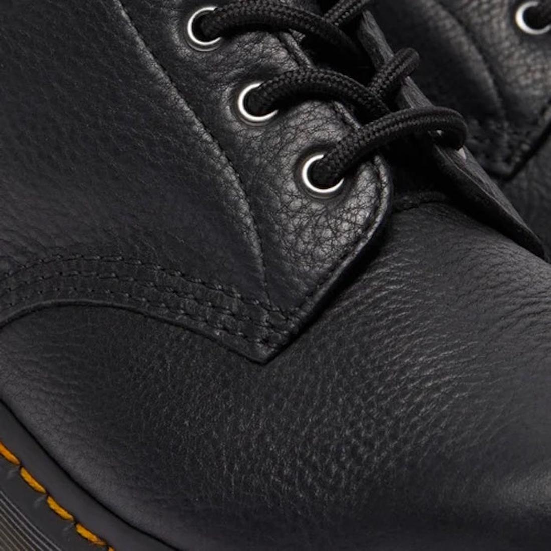 Close-up of the Dr Martens 101 UB Black Ambassador 6 Eye Leather Boot, showing its textured leather, black laces, metal eyelets, visible stitching, and the signature sole edge with yellow stitching., 190665693683, 190665693690, 190665693706, 190665693720,