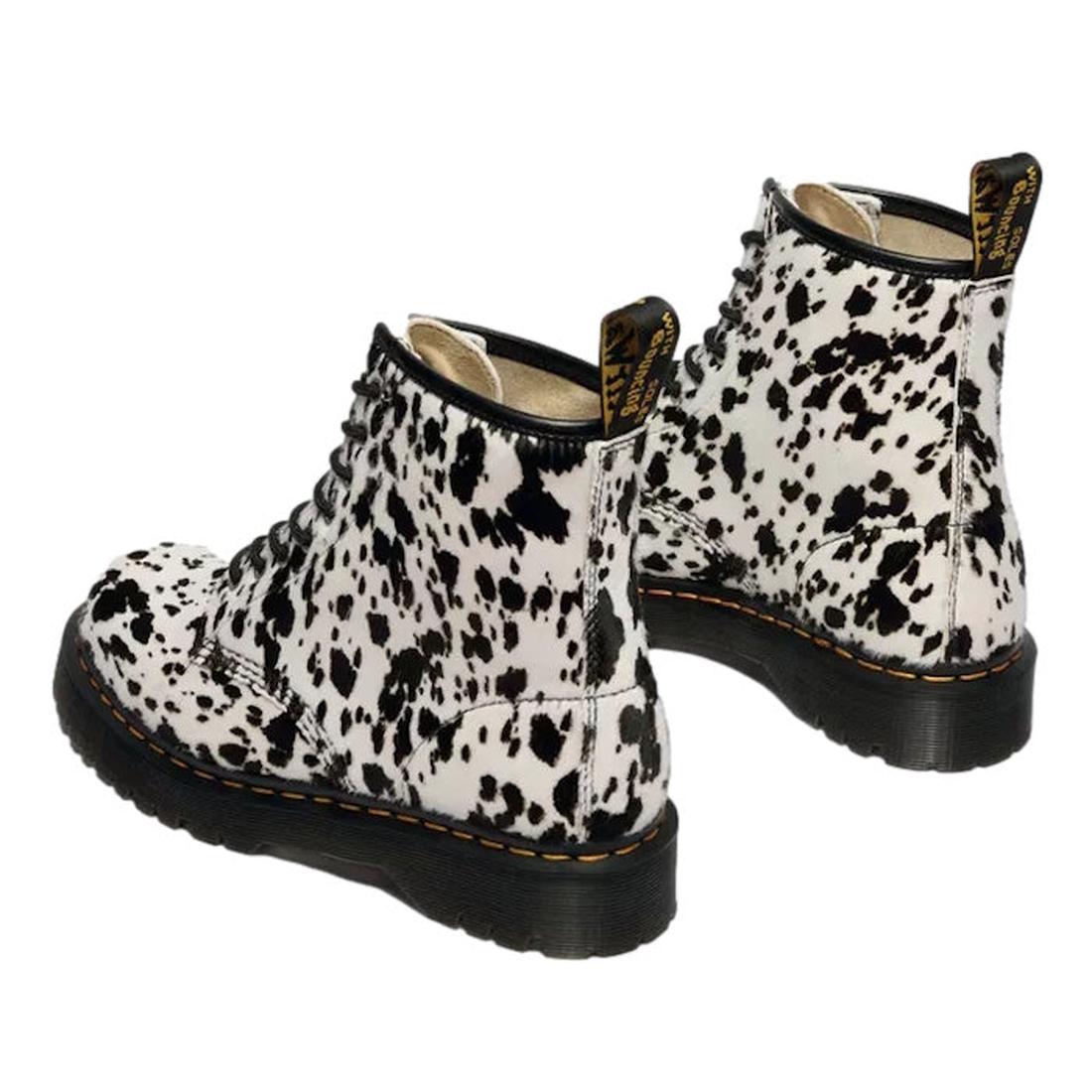 The Dr Martens 1460 Bex Dalmatian Hair On Leather Lace Up Boot features black and white cow print hair-on leather, thick black soles, yellow stitching, and Goodyear welted construction for lasting durability., 190665780307, 190665780314, 190665780321, 190