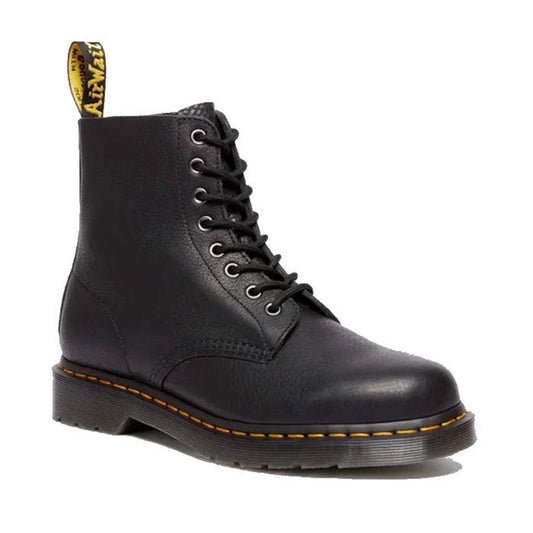 The Dr. Martens 1460 Pascal Ambassador Black Leather boot, with yellow stitching, a Goodyear-welted sole, and a yellow pull tab, is shown laced up in black leather against a white background.
