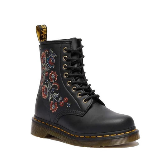 The Dr Martens 1460 Vonda TF Tavern Floral boot in black Genix Nappa leather features side floral embroidery, yellow stitching on a Goodyear-welted sole, and a signature yellow pull tab.