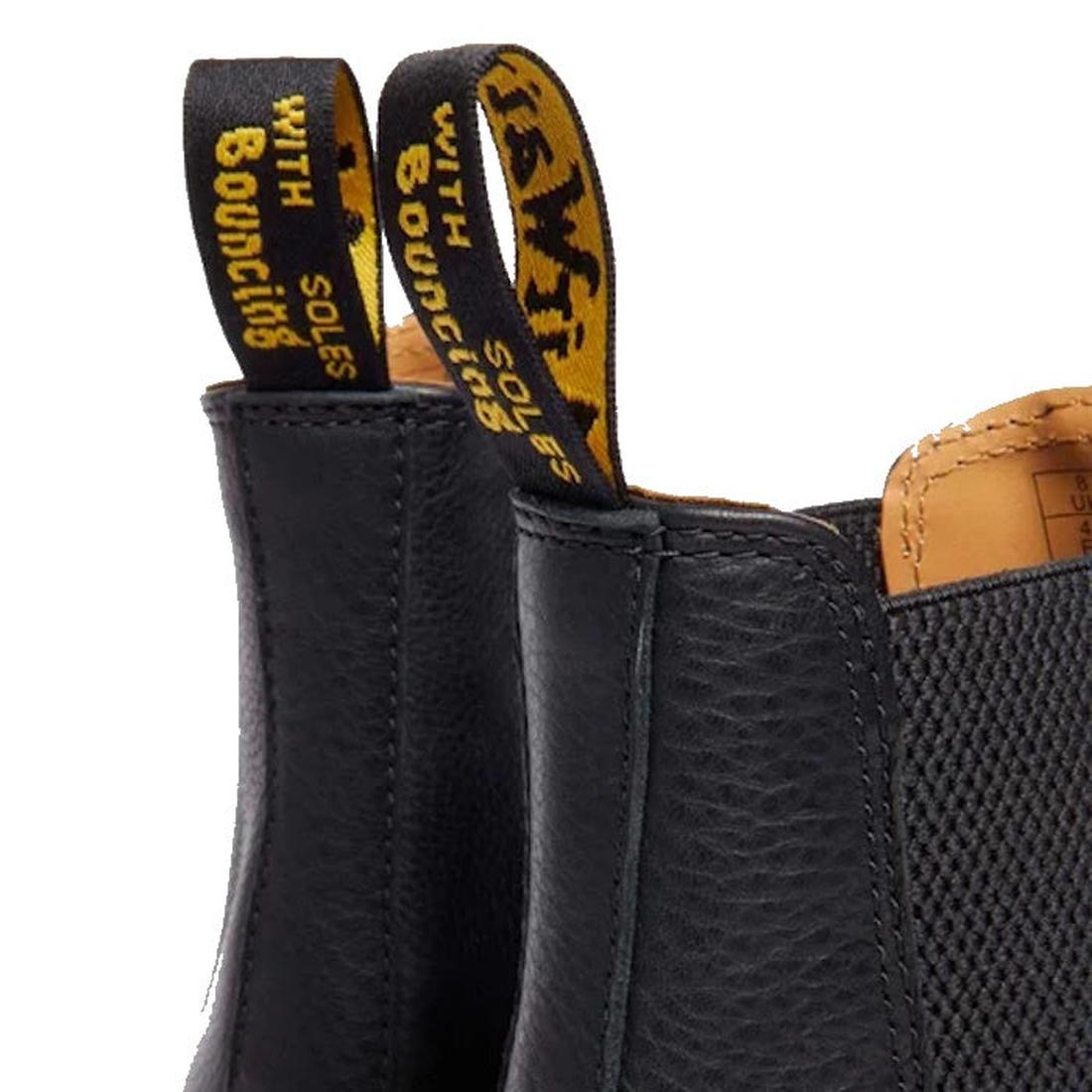 Close-up of the Dr Martens 2976 Ambassador Black Leather Chelsea Boot with yellow and black pull tabs reading WITH BOUNCING SOLES, Goodyear-welted stitching, and textured black leather details visible., 50056, 50057, 50059, 190665663303, 190665663310, 190