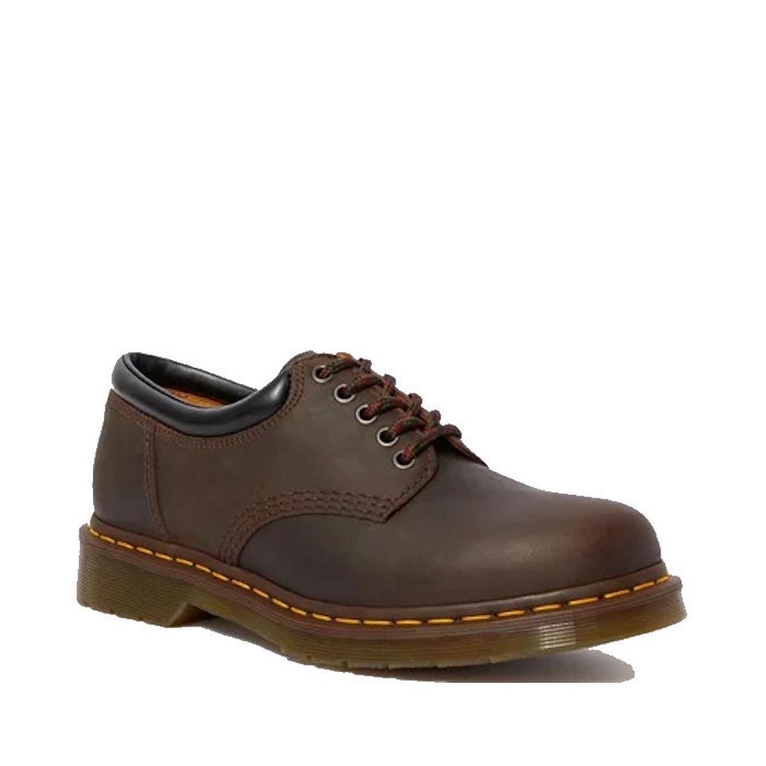 The Dr Martens 8053 Crazy Horse Dark Brown Leather 5 Eye shoe features classic yellow stitching, a black padded collar, and a chunky translucent air-cushioned sole for comfort and timeless unisex style.