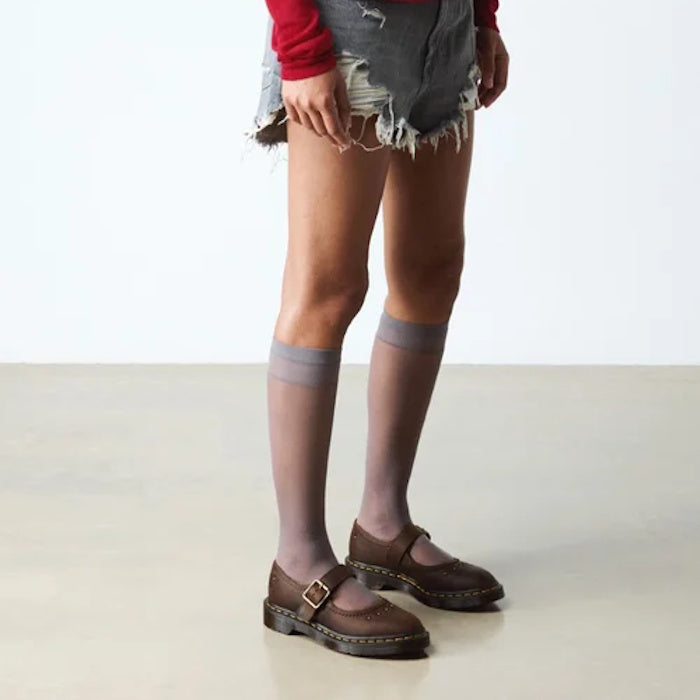 A child wears Dr Martens Doc Mary Jane Flower in Dark Brown Crazy Horse, featuring a sturdy sole and easy buckle closure.  ksnz, 52079, 190665785531, 190665785548, 190665785555, 190665785579, 190665785586, 190665785593
