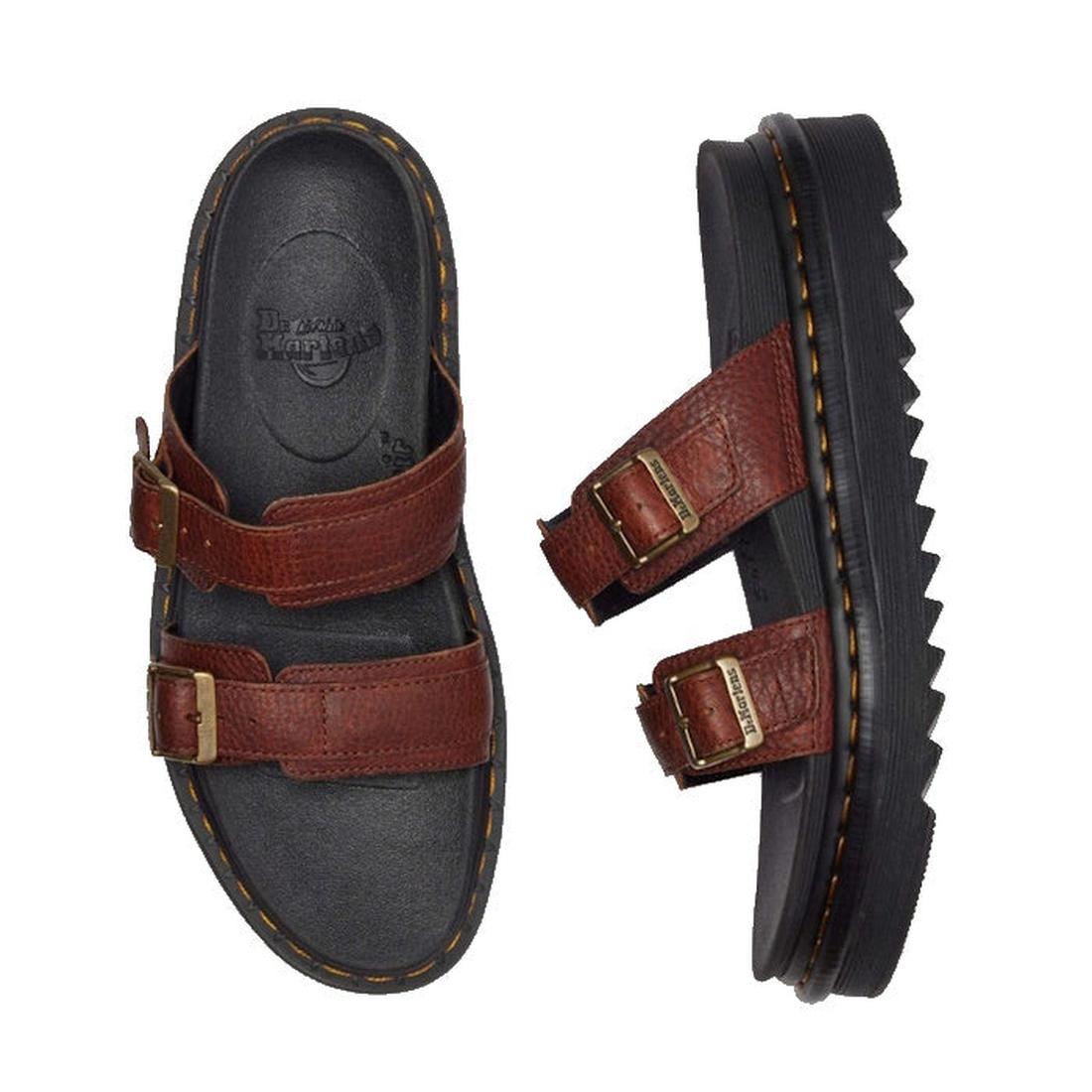 The Dr Martens Myles Cashew Ambassador Brown Leather Sandal features brown straps with gold buckles and chunky black EVA Zebrilus soles. One sandal is shown from the top, the other from the side to highlight its thick ridged sole., 49260, 190665772081, 19