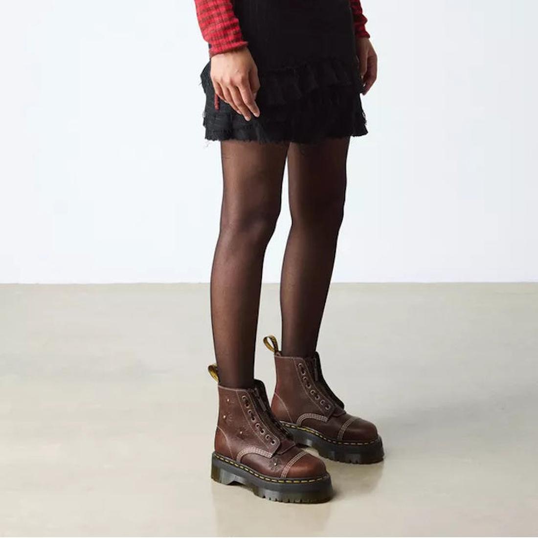 A person wears a black skirt, black sheer tights, and Dr Martens Sinclair Flower Dark Brown Grizzly Leather Boots with a platform Quad sole, standing on a light floor against a plain white background., 51903, 51904, 190665777116, 190665777123, 19066577714