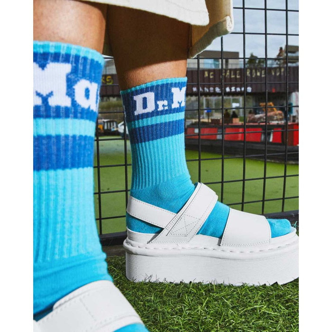 Dr Martens Doc Socks Athletic Logo Turquoise Blue and comfy white platform sandals with easy slip-on fit, shown outdoors on grass.  ksnz, 190665479843, 190665479836