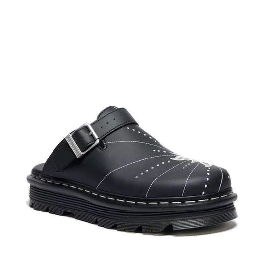 The Dr Martens Zebzag Mule Solar Flare Genix Nappa Black is a black slip-on clog with a thick ergonomic sole, decorative white stitching, and an adjustable buckle strap across the top.