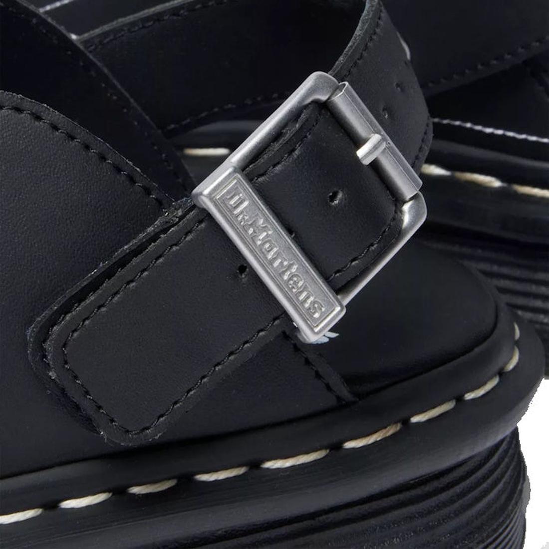Close-up of the Dr. Martens Zebzag Mule Solar Flare Genix Nappa Black sandal featuring a silver buckle engraved with Dr. Martens and white stitching along the ergonomic sole, emphasizing its sturdy construction., 190665758818, 190665758825, 190665758832, 