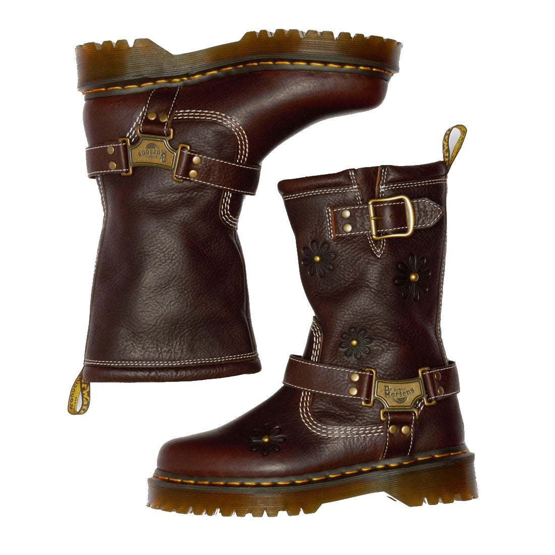 The Dr Martens Anistone Hi Flower Bex Grizzly Dark Brown boots feature yellow stitching, floral embossing, buckles, metal plaques, rugged soles, and back pull tabs for a biker-inspired look.