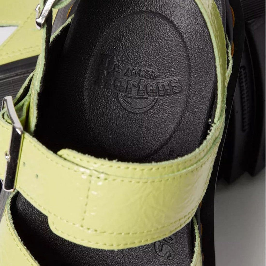 Close-up of a light green Dr Martens - Voss II Cross Strap Sandal in Distressed Patent Lime Green, featuring two buckle straps, the brand logo embossed on the black textured insole, and a visible thick Goodyear welted sole., 41508, 41509, 190665646665, 19