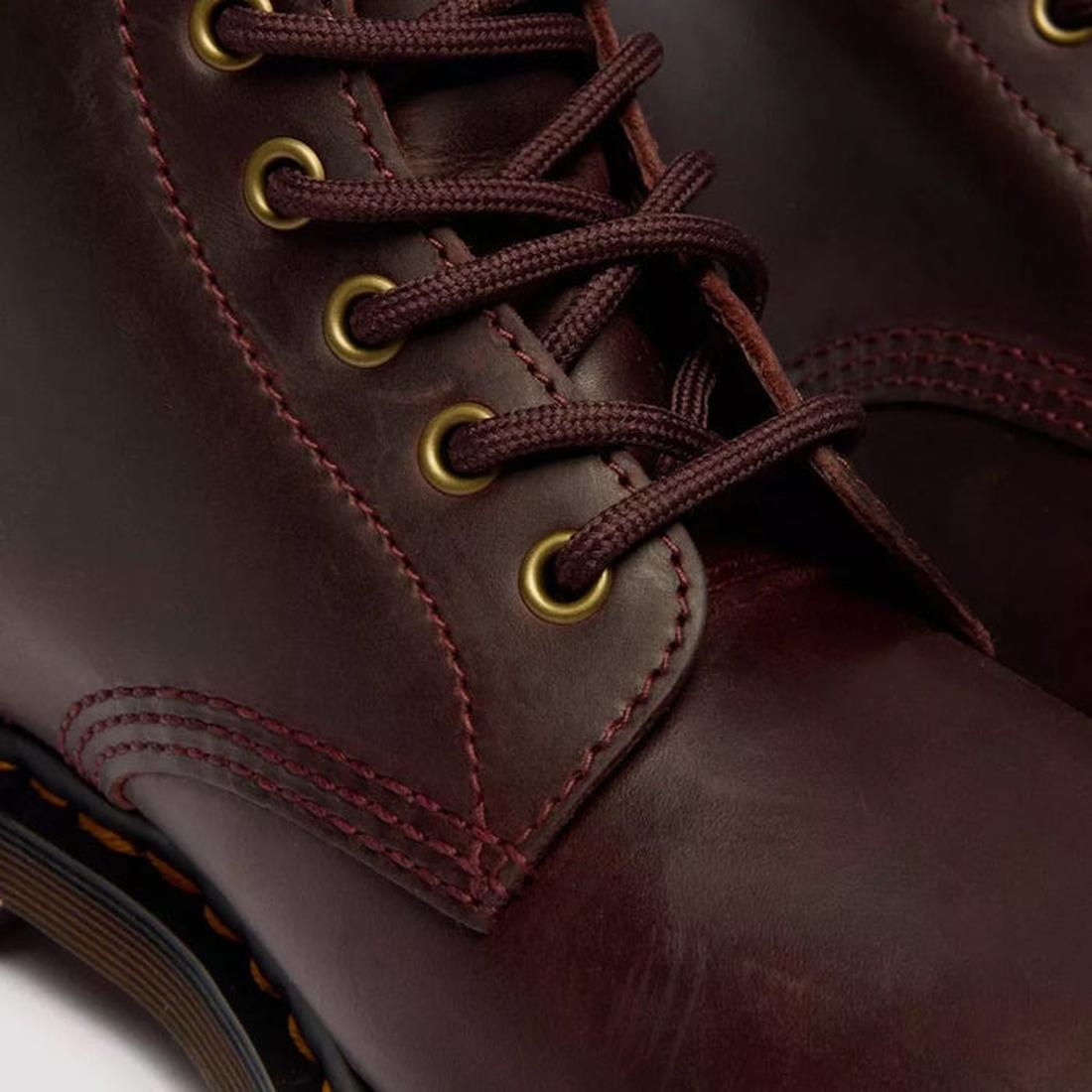 Close-up of Dr Martens 1460 Cherry Red Crazy Horse Waxy Leather 8 Eye Boot, featuring brown laces in brass eyelets, detailed stitching, Goodyear Welted construction, and part of the durable rubber sole., 190665786835, 190665786842, 190665786859, 190665786