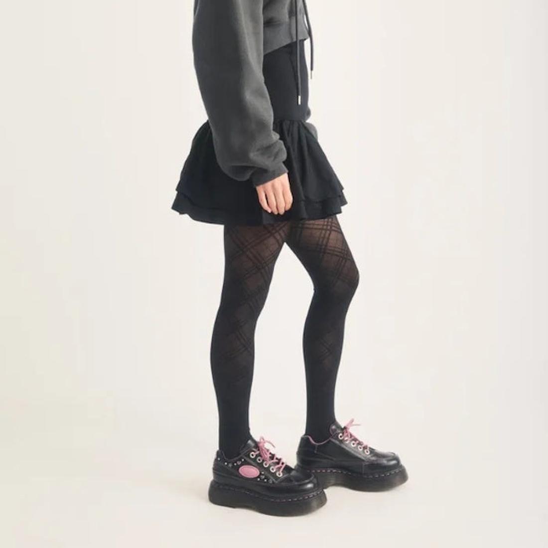 A person wears a dark skirt and patterned tights with Dr Martens Buzz 5i Hearts & Stars Milled Gloss Leather Shoe, featuring pink hearts, stars, and laces on a Goodyear welted sole., 54732, 190665823745, 190665823752, 190665823776, 54736, 54737
