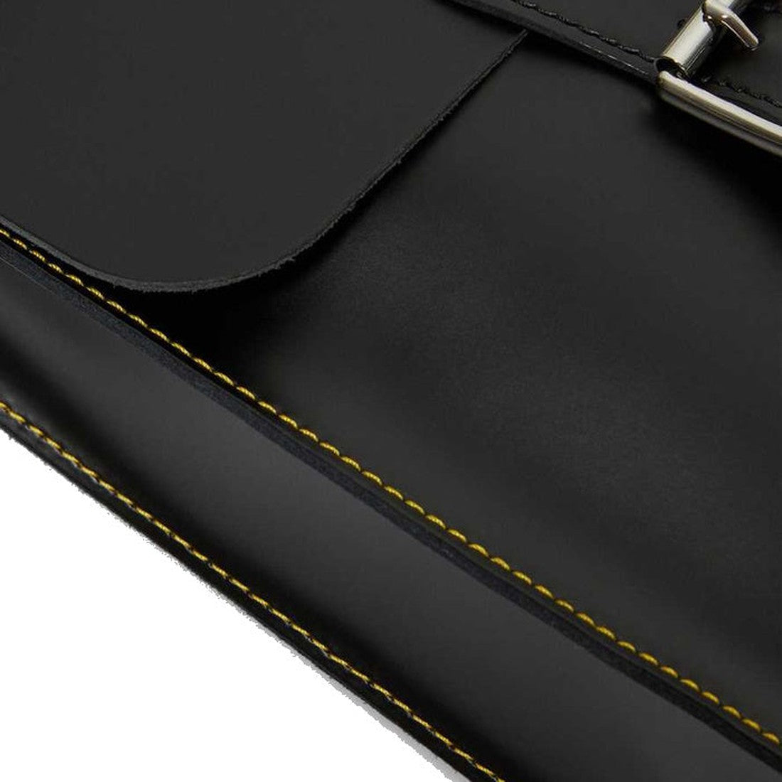 Close-up of the Dr Martens Mini Leather Backpack Black, featuring smooth black leather, bold yellow stitching, and a silver buckle for a 90s-inspired look., 190665192032