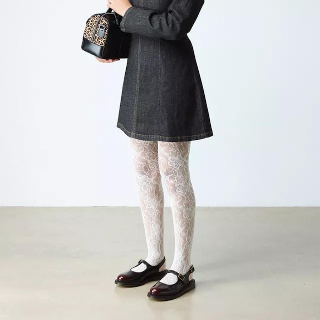 A person in a dark dress and white lace-patterned tights stands on a light floor, holding a small leopard-print handbag. They wear Dr. Martens Madaline Cherry Red Arcadia Women's Slingback Mary Jane Shoes; their face is not visible.
