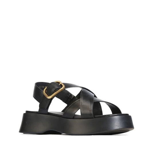 The EOS Barista Black Leather Platform Sandal is a contemporary women’s shoe featuring wide crisscross black leather straps, an eye-catching gold buckle, and an open toe and back design. Leather-lined and showcased against a white background, this sandal 