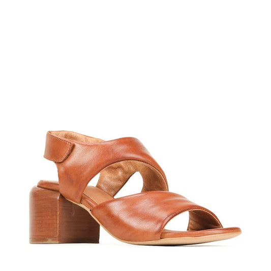 The EOS Charbel Brandy Tan Leather Block Heel Women's Sandal features a mid-height block heel, open toe, adjustable ankle strap, and soft curved leather panels for comfort and style.