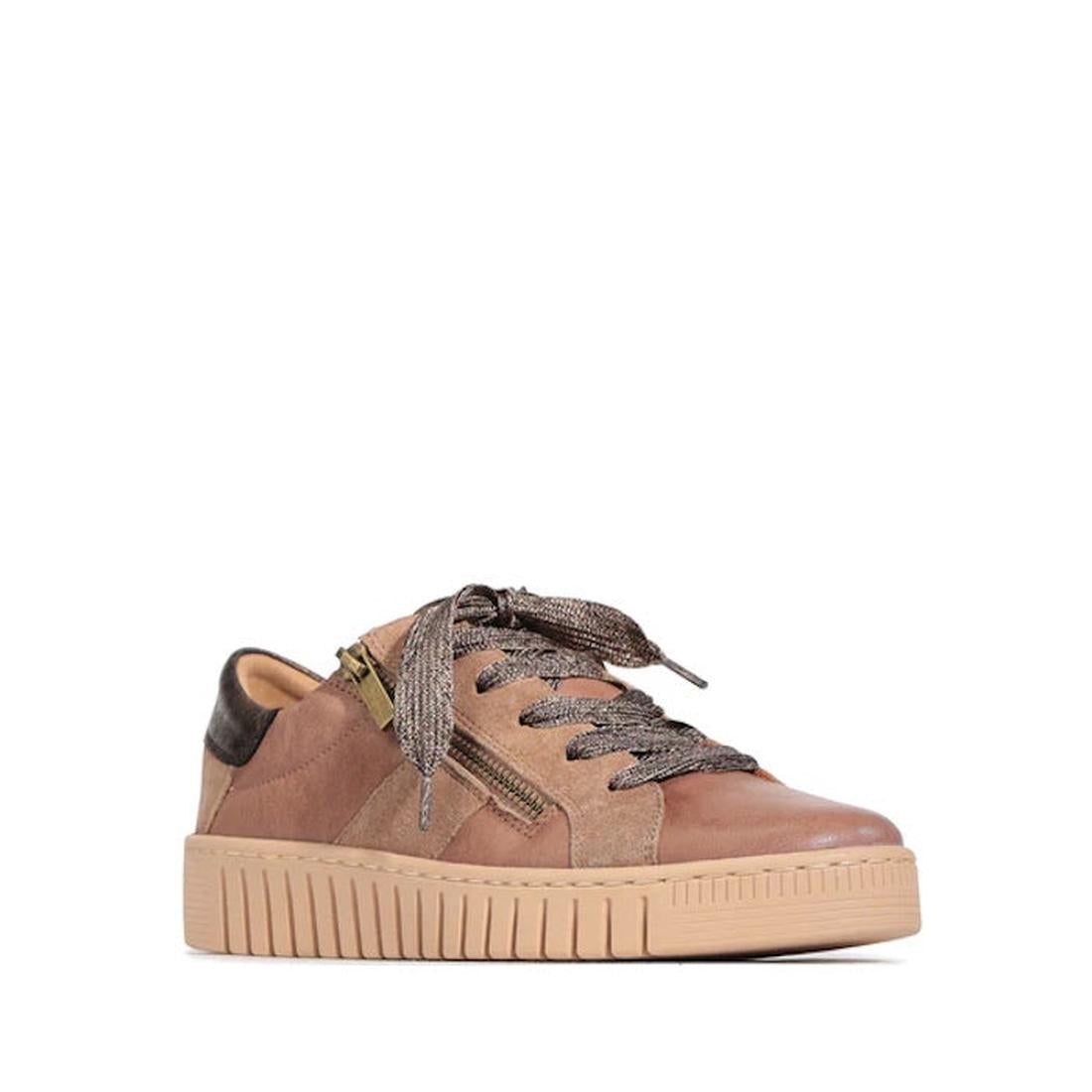 The EOS Tinah Oak Light Brown Leather Trainer features a contemporary design with a mixed-material upper, thick rubber sole, metallic-textured laces, side zipper, and dark brown heel accent, shown on a white background.