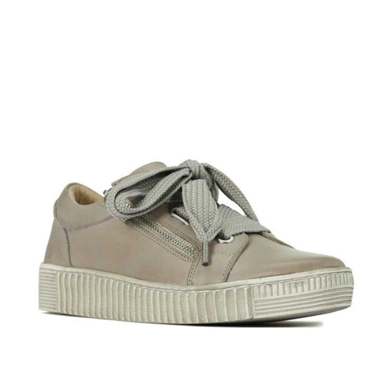 The EOS Jovi Leather Trainer in Stone features Italian Aniline leather, thick wide laces in a large bow, textured side details, a chunky ribbed white sole, and an angled view showing both side and front.