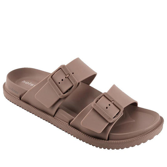 The Holster Soleseeker Natural Summer Women’s Slide is a taupe-colored sandal featuring two adjustable buckle straps and a textured sole, designed with enhanced arch support for all-day comfort and shown at an angle on a white background.