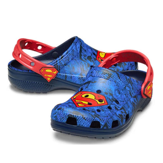 The Crocs Kids - Superman Classic Clog Blue in junior youth sizes features red straps and a comic book Superman print with emblems on the front and sides.