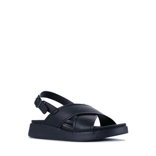 The Los Cabos Bogota Black Womens Summer Sandal Back Strap has a thick sole, open toe, wide criss-cross vegan leather straps, a comfy footbed, and an adjustable slingback buckle. Pictured on a white background.