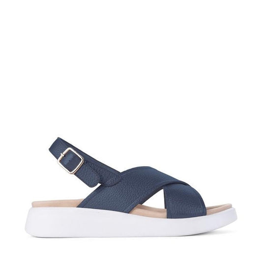The Los Cabos Bogota Navy Women's Summer Sandal features crisscross vegan leather straps, an adjustable ankle buckle, a comfy footbed, and a thick white sole, displayed in side profile on a plain white background.