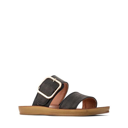 The Los Cabos Doti Black Raffia Light Flexible-Sandal features two wide straps, a large gold buckle on the upper strap, and a flat tan sole—perfect black slip-on sandals for women seeking style and comfort this summer.