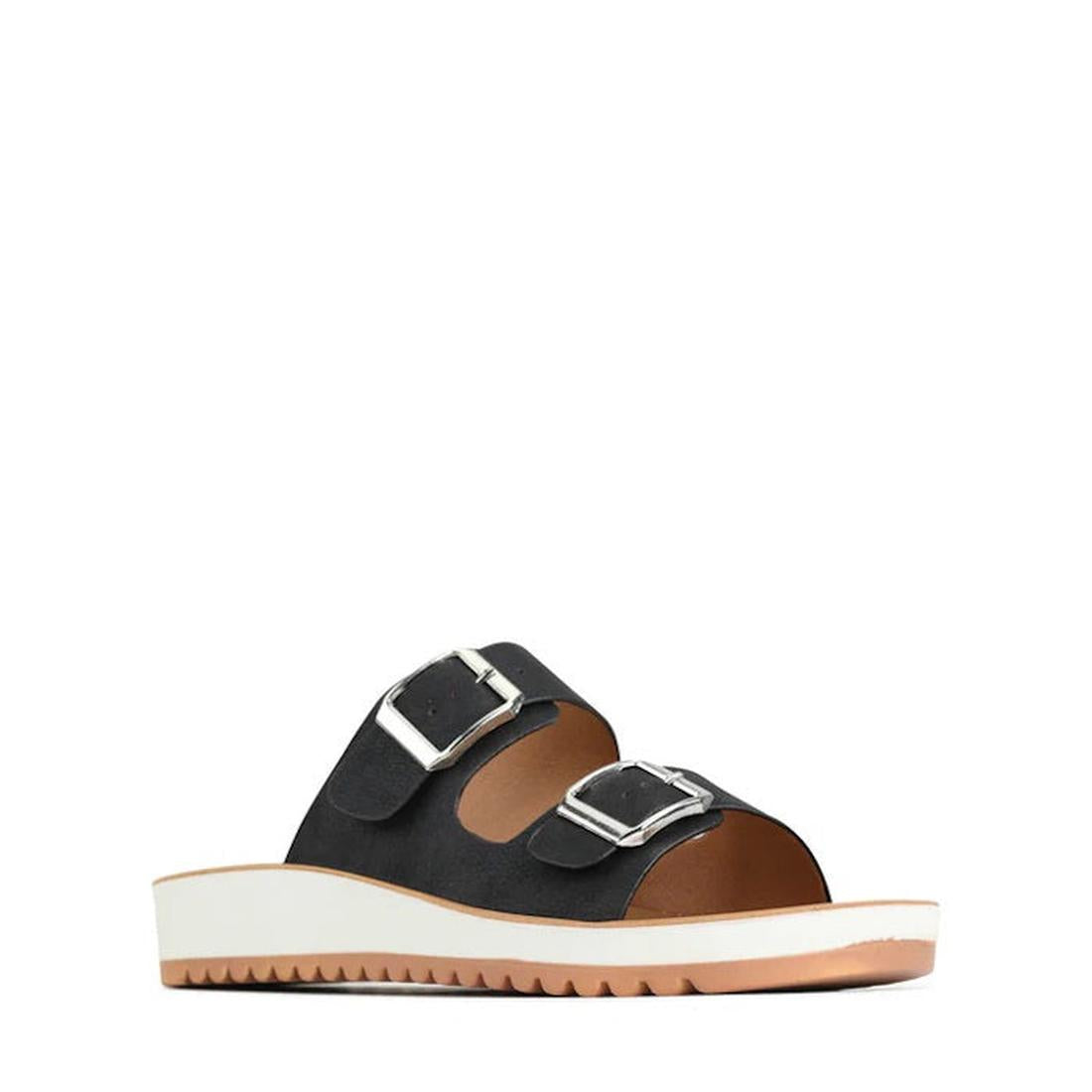 The Los Cabos Naara Black Adjustable Summer Womens Slide Sandal features two wide vegan leather straps with large silver buckles, a brown insole with arch support, and a white ridged platform sole, displayed on a white background.