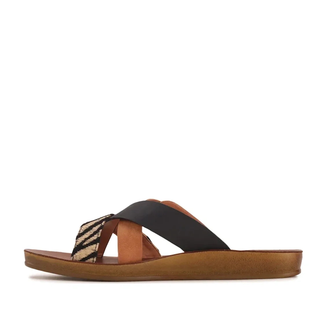 A side view of the Los Cabos Brik Black Brandy Zebra Women’s Slide Sandal highlights its flat, lightweight design, featuring crisscross black and zebra-print straps, an anatomical footbed with a tan cushioned sole, and an open toe silhouette.