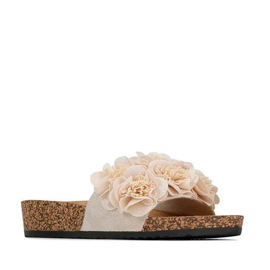 Los Cabos Corsage Natural Flower Women’s Slides feature a cork sole and are adorned with soft pink fabric flowers clustered on the top strap, making them the perfect summer shoe. Displayed against a white background.