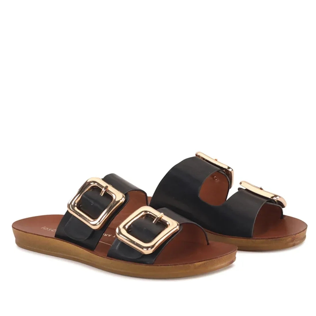 A pair of Los Cabos Womens Dina Black Light Flexible Two Strap Slide Sandals, featuring large gold buckles on brown anatomical footbeds with flat soles for comfortable arch support. The sandals are displayed at a slight angle against a white background.