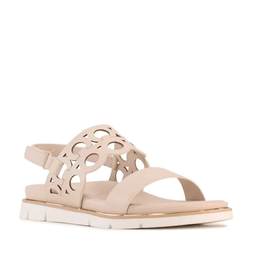 The Los Cabos Terica Bone Sandal With Back Strap features a beige flat design with a white sole, an open toe, and a cut-out circular pattern on the upper strap. It also includes an adjustable slingback ankle strap with a buckle for supportive comfort.