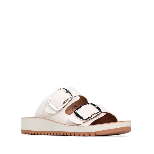 The Los Cabos Naara White Adjustable Summer Womens Slide Sandal is shown on a plain white background, featuring two wide white straps with large silver adjustable buckles, a brown insole designed for enhanced arch support, and a chunky white sole with a s