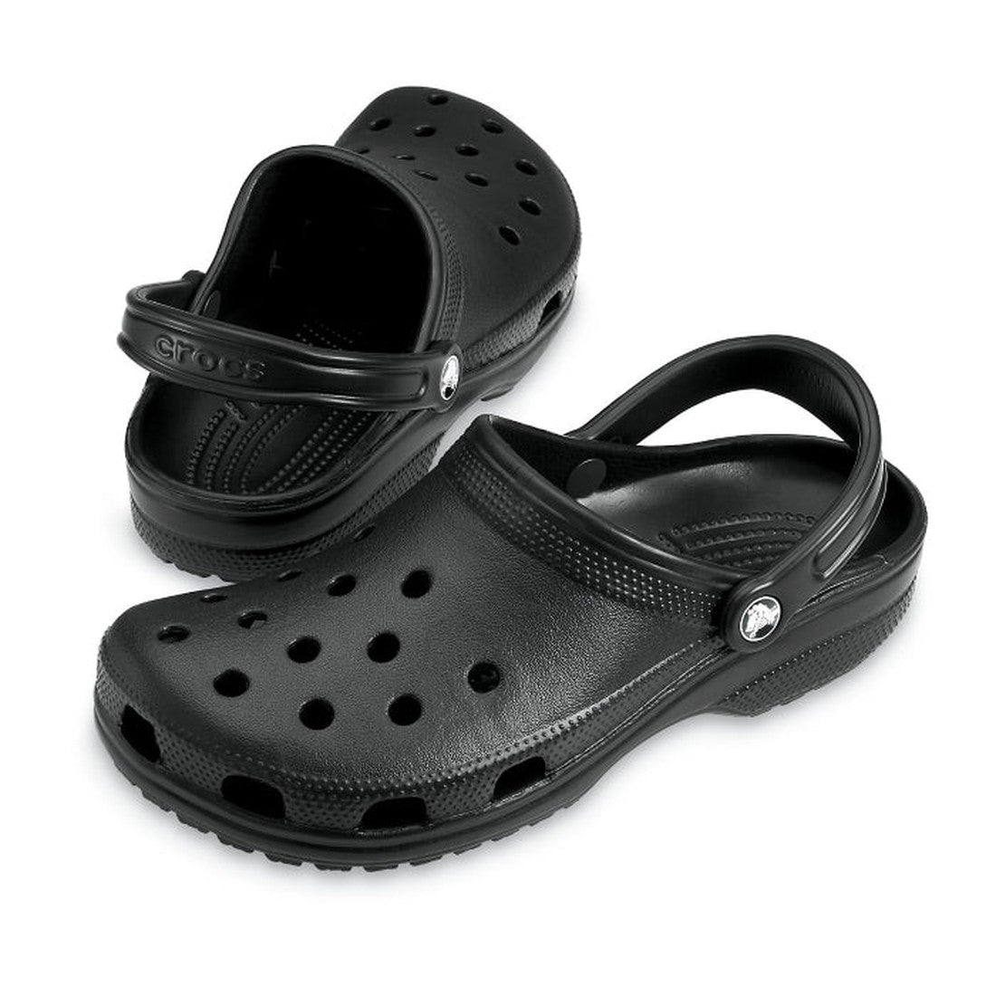 A pair of Crocs - Classic Clog Black Adults womens & mens, featuring ventilation holes and adjustable heel straps, with one clog upright and the other tilted on its side.