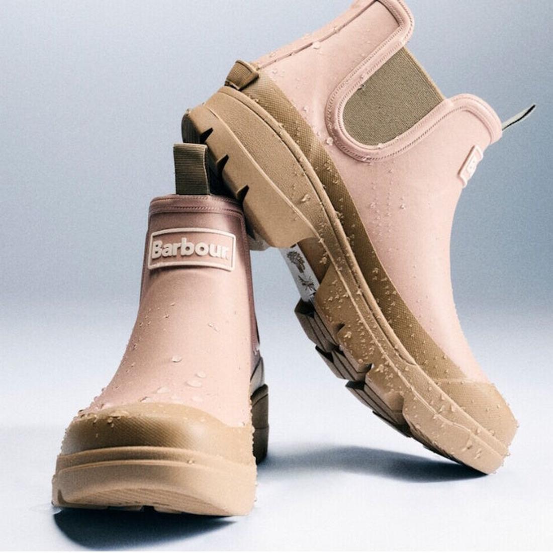 Two Barbour Nimbus Gardenia Pink/Bleached Olive Chelsea Wellingtons women's rainboots with chunky tan soles and elastic side panels, shown with water droplets on the surface against a light gradient background., 5063669171745, 5063669171752, 5063669171769