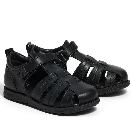 The Pretty Brave Apollo Black Leather School Sandal is a unisex children’s sandal made from genuine leather, featuring closed toes for protection, side cutouts, adjustable hook-and-loop straps, and sturdy rubber soles.