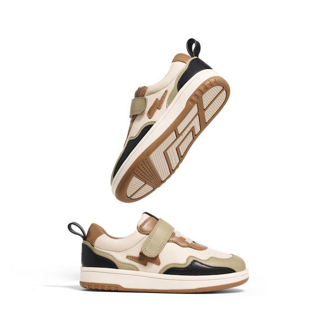 Two Pretty Brave Icon Trainer Lightning sneakers in sage green leather are displayed against a white background—one upright, the other balanced on its toe—showcasing their modern design and textured sole.