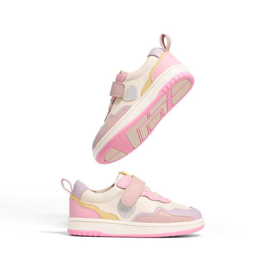 Two Pretty Brave Icon Trainer Sparkle Hearts Pink Leather shoes are displayed on a white background—one upright, the other above it. They feature pink soles, velcro straps, and cream, yellow, and lavender accents.