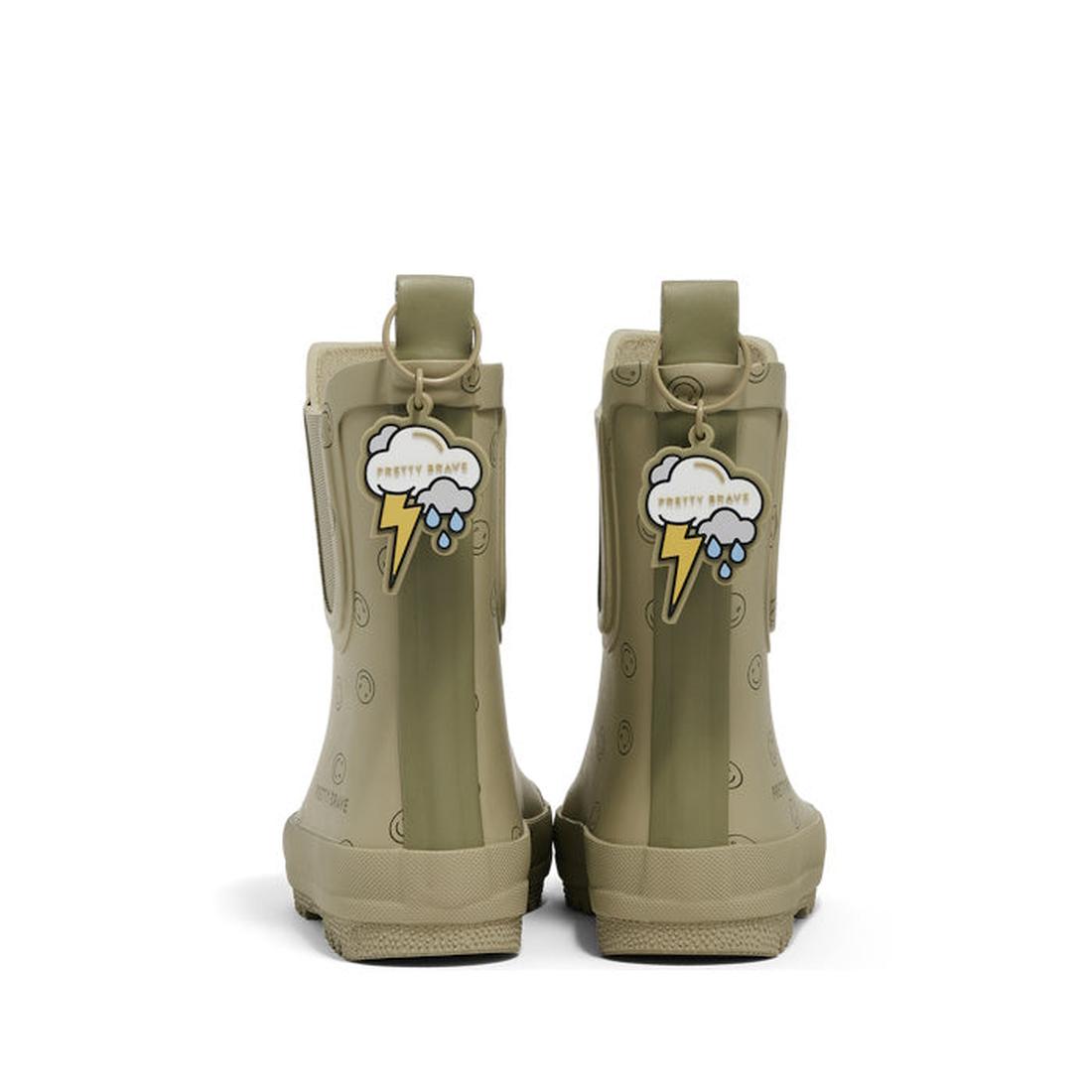 A pair of Pretty Brave Puddle Boot Ankle Rainboot Sage Green Smiley kids boots, shown from the back, with smiley faces and a tag featuring a cartoon cloud, lightning bolt, and “PRETTY BRAVE.”., 9420075347434, 9420075347427, 9420075347410, 9420075347403, 9