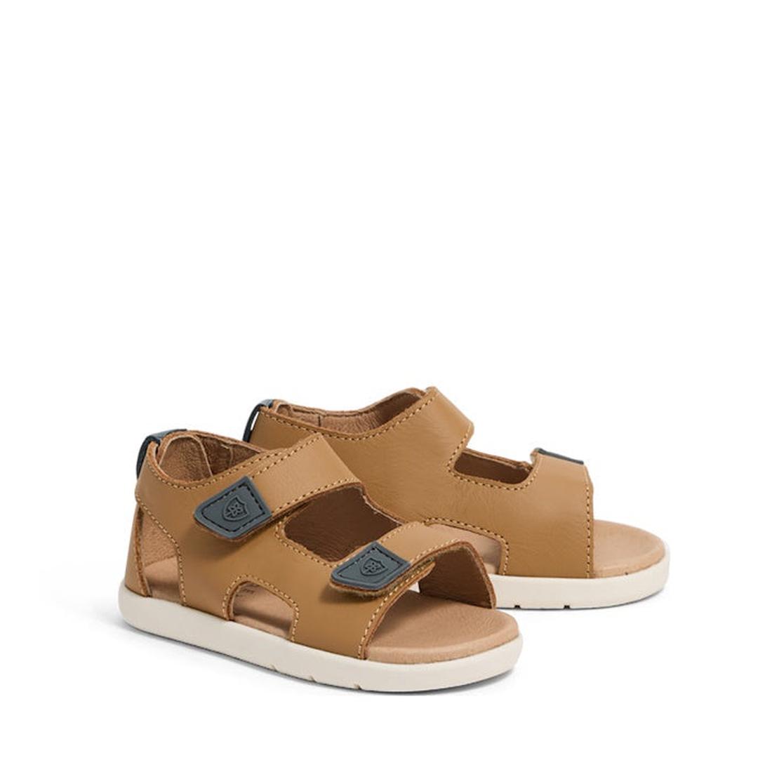 The Pretty Brave 1st Walker Jack Tan Leather Open Toe Sandals for kids feature white soles and adjustable dark gray Velcro straps, shown side by side on a white background.
