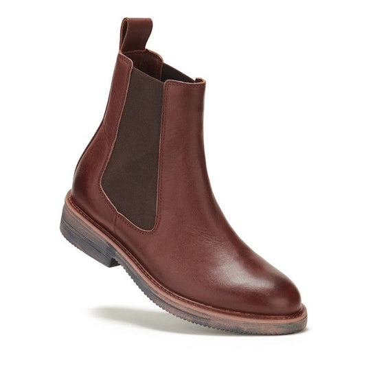 The Rollie Womens Chelsea Rise Vintage Mocha Leather Boot features premium brown leather, an elastic side panel, pull tab, low stacked heel, and textured Vibram outsole. Shown against a white background.