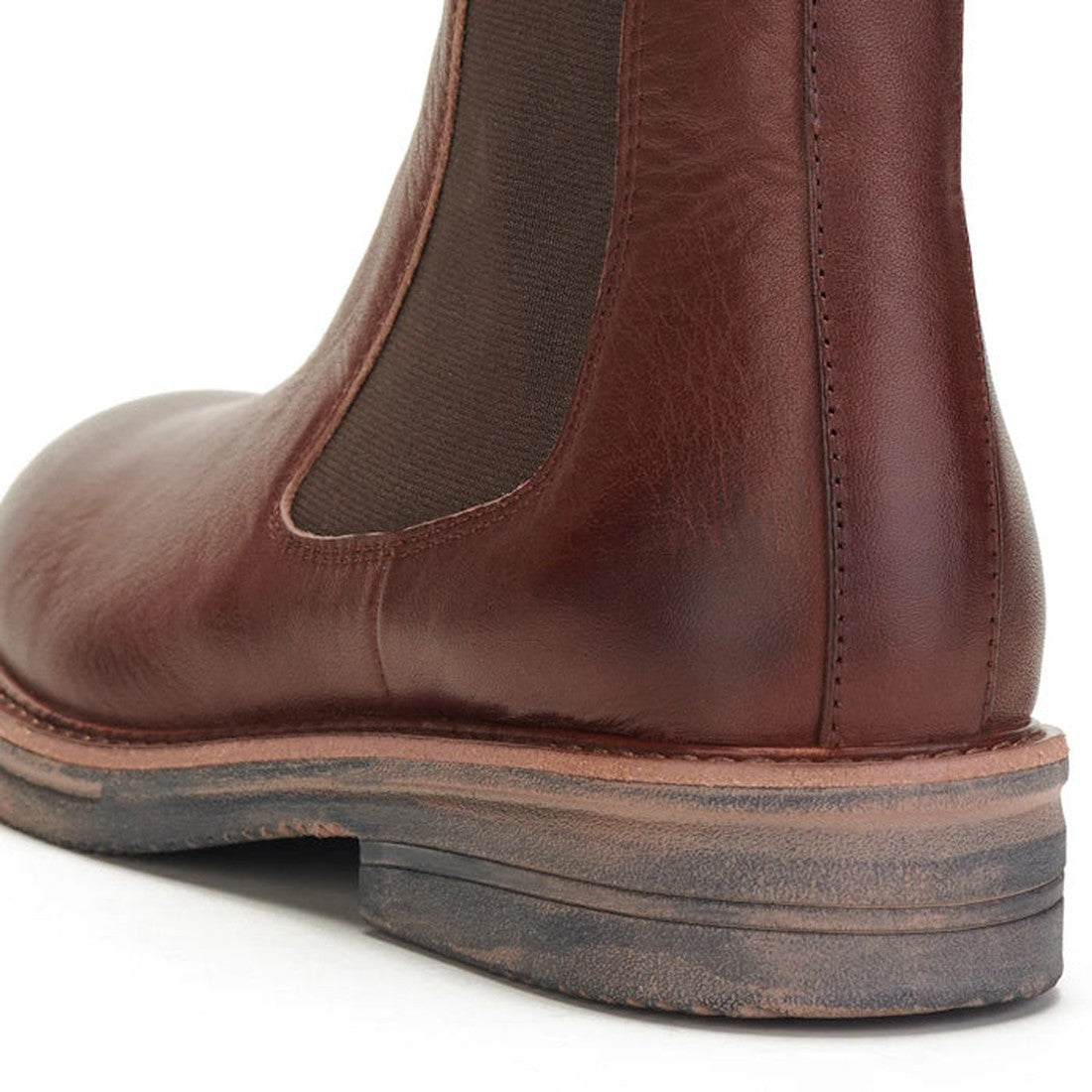 Close-up of the heel and side of the Rollie Womens Chelsea Rise Vintage Mocha Leather Boot, featuring brown premium leather, an elastic panel, detailed stitching, and a slightly worn Vibram outsole., 9339554341682, 9339554341699, 9339554341705, 9339554341