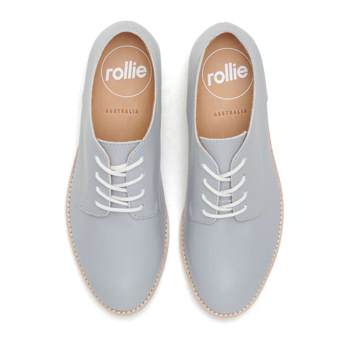 The Rollie Womens Derby Super Soft Stone Leather Shoe features light gray premium leather, white laces, tan soles, and cushioned comfort. From above, the tan insoles display the rollie AUSTRALIA logo in white., 9781760763930, 9781760763947, 9781760763954,