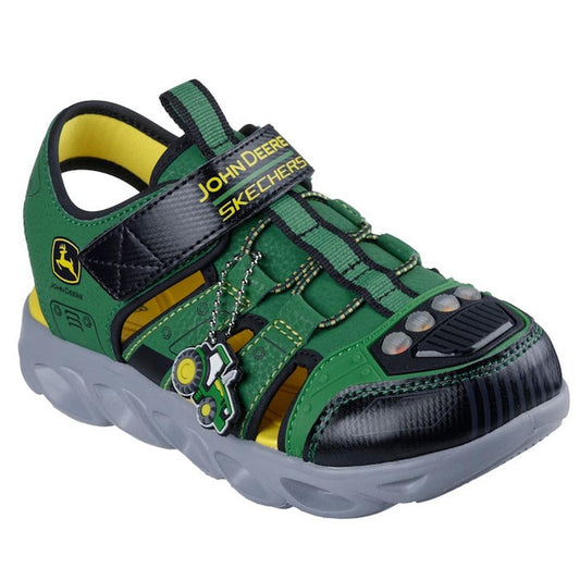 The Skechers Kids Hypno Splash John Deere Light Up Sandal features a green and black design with yellow accents, a tractor charm, adjustable strap, thick gray sole, and fun branding—perfect for adventurous kids.