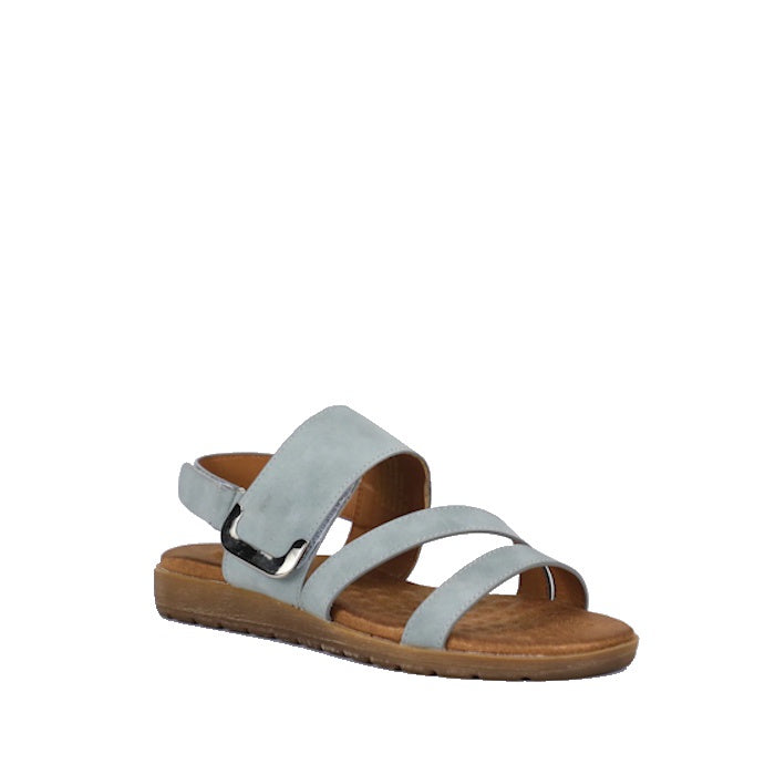 The Soultbush Flinders Denim Women’s Sandal with Back Strap is a light blue sandal featuring three straps and an open toe, complemented by a brown flat sole and a cushioned footbed for all-day comfort. An adjustable Velcro back strap ensures a secure fit.